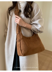 Sac hobo en suédine marron porté épaule avec bandoulière réglable et texture mate douce
