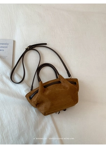 Dettaglio della borsa tote minimalista in pelle scamosciata marrone scuro opaca con tracolla