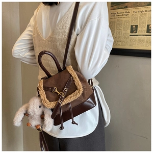 Detail view of brown vintage backpack with faux fur trim and cute bunny charm accessory