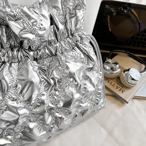 Detail der silbernen gesteppten Beuteltasche mit Kordelzug und Metallic-Oberfläche