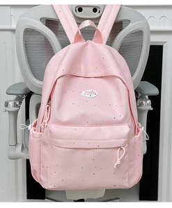 Detaillierte Vorderansicht des rosa gepunkteten Rucksacks mit Taschen und robustem Stoff