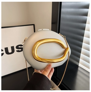 Detail van de parelmoer avondtas met gouden ronde handgreep en afneembare kettingriem