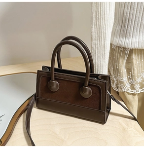 Vintage brown leather crossbody bag detail with circular handle base and suede stitching
