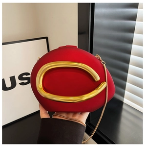Detail van de rode matte avondclutch met gouden C-vormig handvat en slangenketting