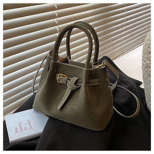 Detail of dark olive green matte bucket bag with vintage gold buckle and top handles