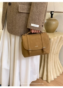 Dettaglio della borsa retrò in pelle marrone caramello con fibbie vintage e cinturini fini