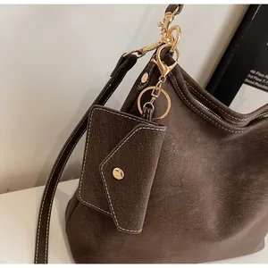 Détail du sac hobo en cuir marron foncé avec surpiqûres blanches et garnitures dorées