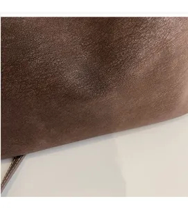 Détail du sac en cuir marron foncé à grain litchi avec logo Muonjin doré