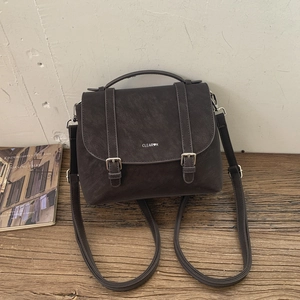 Dettaglio di uno zaino vintage in similpelle marrone scuro con fibbie metalliche