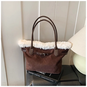 Détail du sac cabas en daim marron avec bordure en fausse fourrure blanche sur un banc