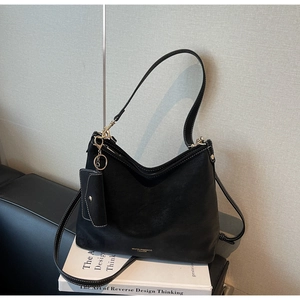 Détail du sac cabas en cuir noir avec surpiqûres blanches et une petite pochette zippée