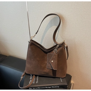 Détail du sac Hobo en daim marron avec large bandoulière et pochette assortie