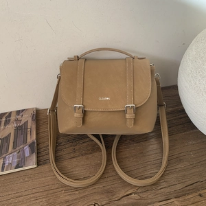 Dettaglio dello zaino vintage kaki con cinturini in pelle e fibbie in metallo argentato