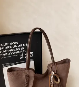 Dettaglio della borsa tote in pelle scamosciata marrone con manico in pelle rinforzata
