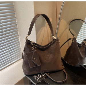 Détail du sac hobo en daim marron foncé avec ferrures dorées et petit porte-monnaie attaché