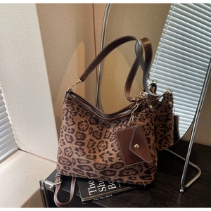 Détail du sac cabas léopard avec lanières en cuir marron et petit porte-monnaie assorti