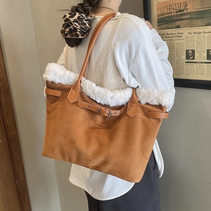 Détail du sac cabas en daim marron avec bordure en fausse fourrure blanche et boucle