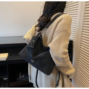 Détail du sac cabas vintage noir avec mini pochette assortie et boucles dorées sur bandoulière