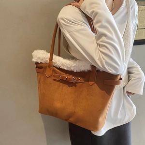 Détail du sac cabas en daim marron avec garniture en fausse fourrure blanche et sangle