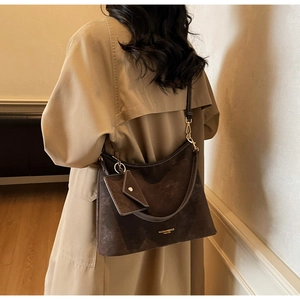 Détail d'un sac cabas en daim marron foncé avec un petit porte-monnaie assorti amovible
