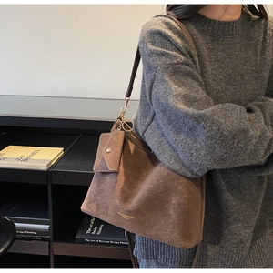 Vue détaillée du sac à bandoulière en daim marron mat avec mini porte-monnaie et logo doré