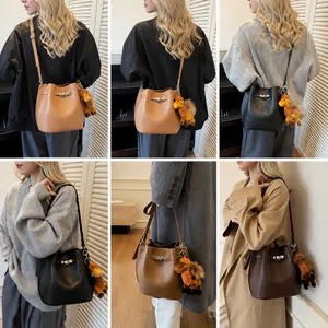 Detail view of retro bucket bags with silver metal turn-lock and leather texture in three colors