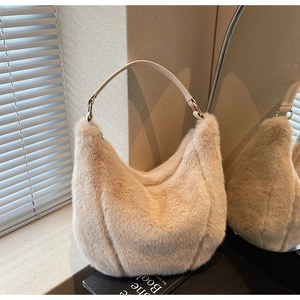 Detailed macro view of beige faux fur texture and gold ring hardware on hobo bag