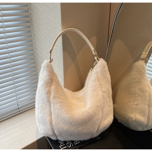 Close-up of fluffy beige faux fur shoulder bag with white leather handle and gold rings