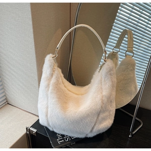 Detail of soft white faux fur hobo bag with round leather handle and gold hardware
