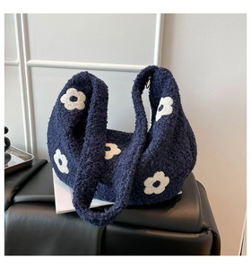 Détail du sac polaire bleu marine avec application de fleur blanche et texture douce
