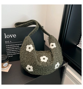 Vue détaillée montrant la texture tricotée et le motif floral blanc du sac vert olive