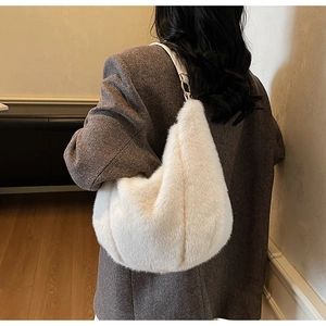 Detailed side view of a white plush crescent shoulder bag with soft faux fur texture