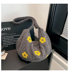 Détail d'un sac hobo en peluche grise avec motifs floraux jaunes et texture douce