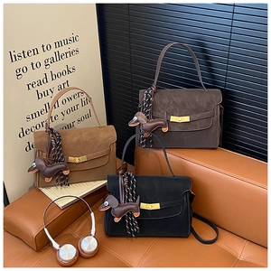 Close-up of vintage square handbags in three colors with dachshund charms and gold locks