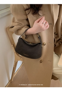 Detail of dark brown matte leather hobo bag with gold twist lock and elegant engraving