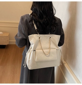 Zaino grande bianco trapuntato con catena dorata mostrato su una modella