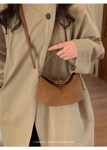 Brown suede crescent bucket bag shown with a trench coat for an elegant casual look