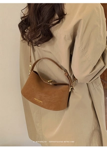 Minimalist retro brown leather bucket bag styled on model with a beige trench coat