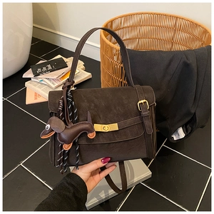 Detail of vintage coffee brown crossbody bag with bronze metal clasp and puppy charm