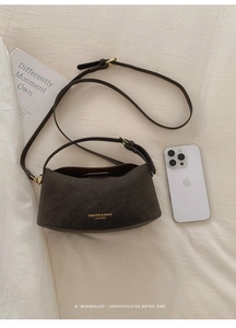 Macro view of dark brown leather handbag texture with adjustable bronze metal strap