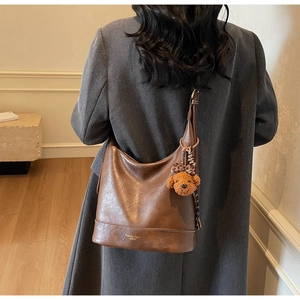 Brown vintage leather tote bag shown on model back view in a minimalist modern interior