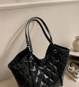 Dettaglio di una borsa shopper trapuntata nera con interno ampio e spalline sottili
