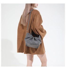 Détail du sac seau nuage gris plissé avec texture mate et poignée en anneau métal