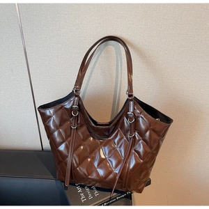 Dettagli della borsa tote trapuntata marrone scuro con cuciture e fibbie metalliche