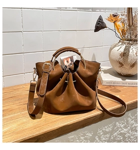 Détail du sac seau marron caramel avec poignée anneau doré et fermeture à cordon coulissant