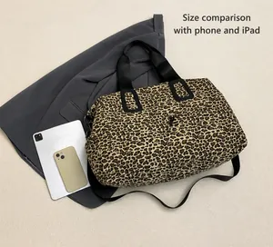 Dettaglio della capiente borsa leopardata con confronto dimensioni tra iPad e cellulare