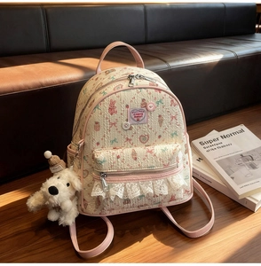 Détail d'un mini sac à dos floral avec bretelles roses et charmant pendentif chien en peluche