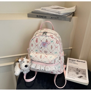 Détail du sac à dos imprimé ours avec bordures en dentelle et broderie cerise en cœur