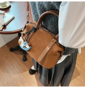 Brown leather Boston bag detail with embossed lettering and small horse charm