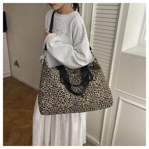 Grande borsa tote leopardata con cinturini in nylon nero indossata da una modella